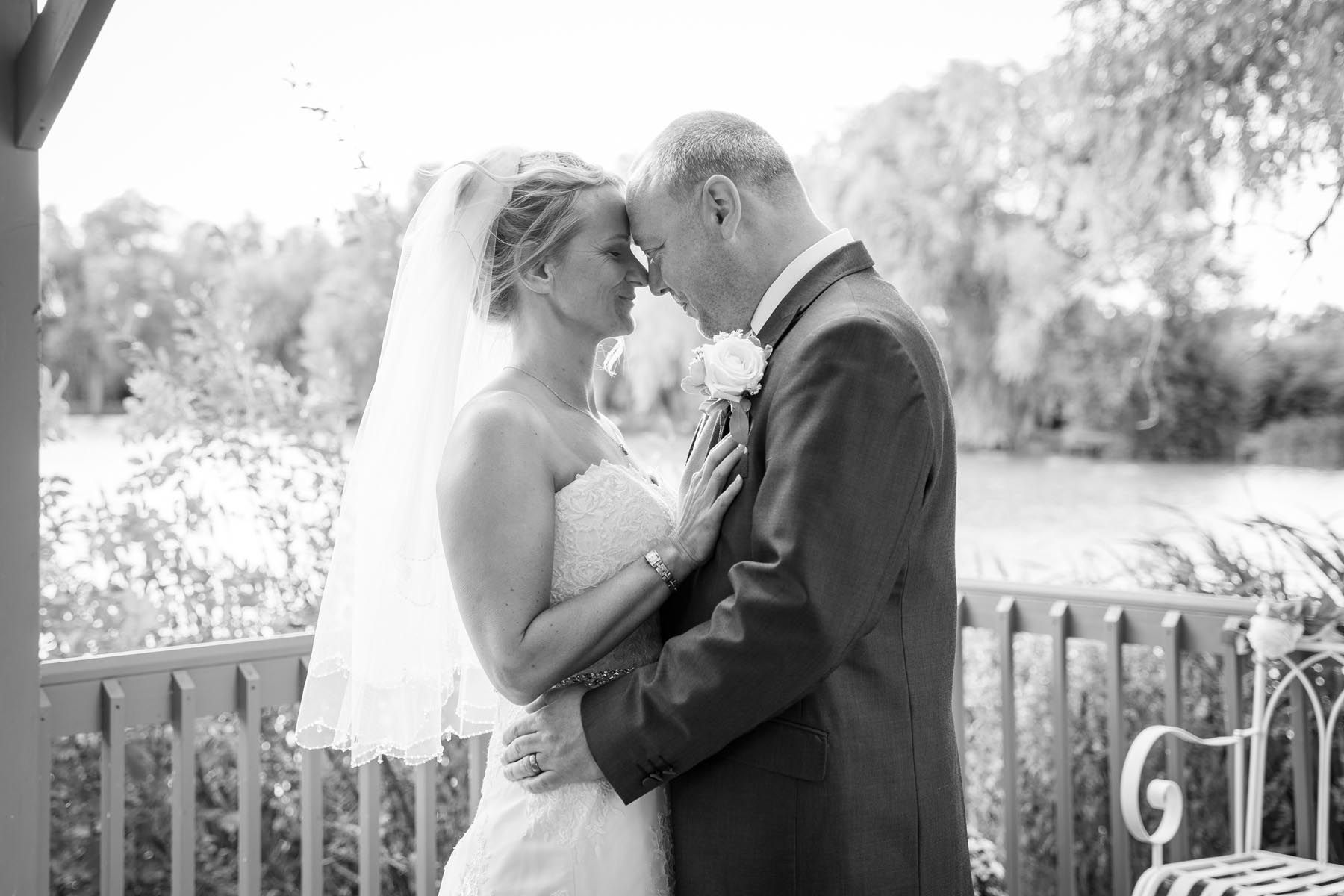 A bride and groom are kissing in a black and white photo.