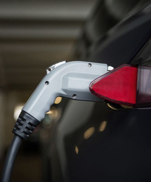 A close up of an electric car being charged