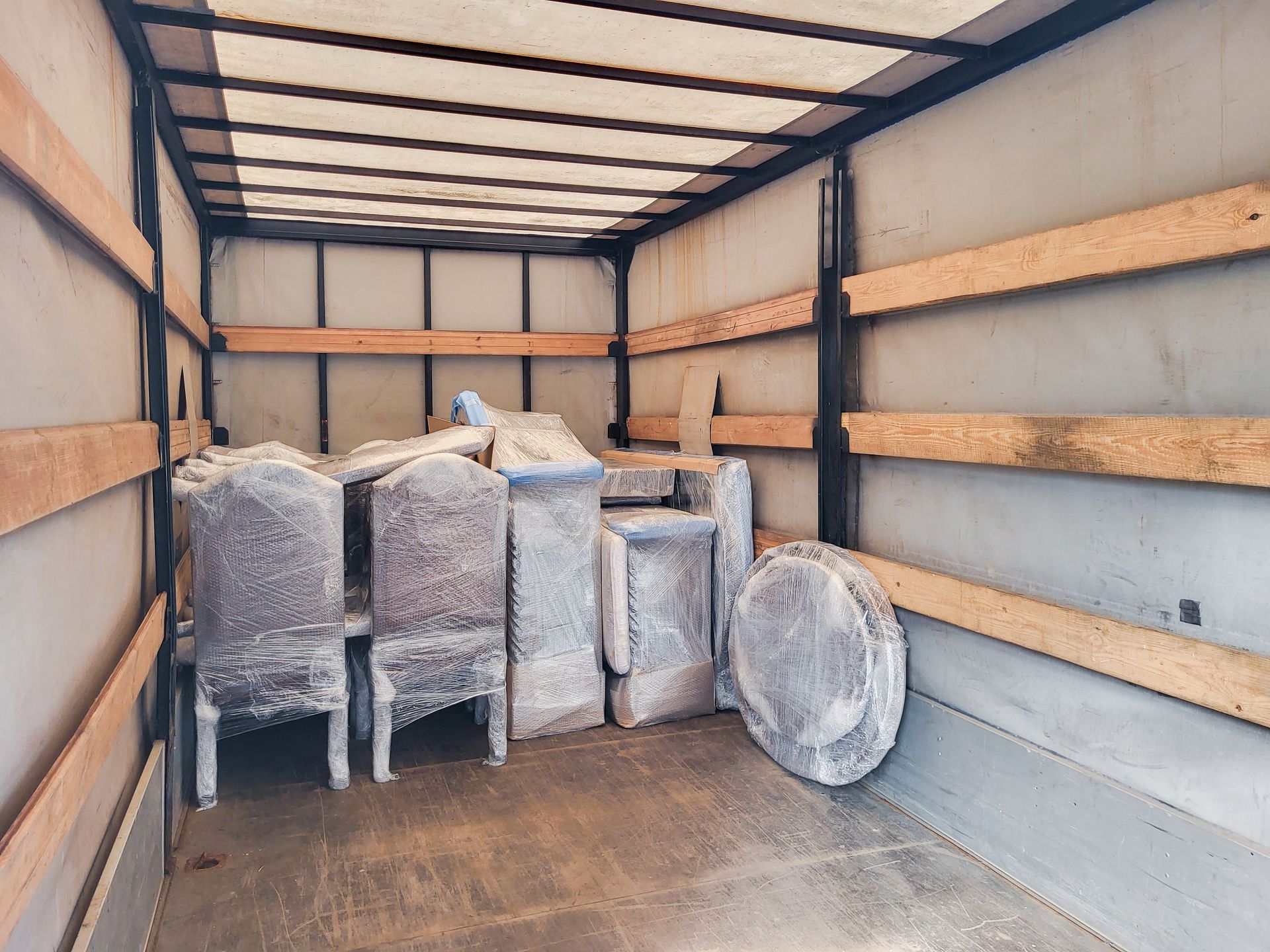 Truck interior packed with wrapped furniture and stacked items during a move