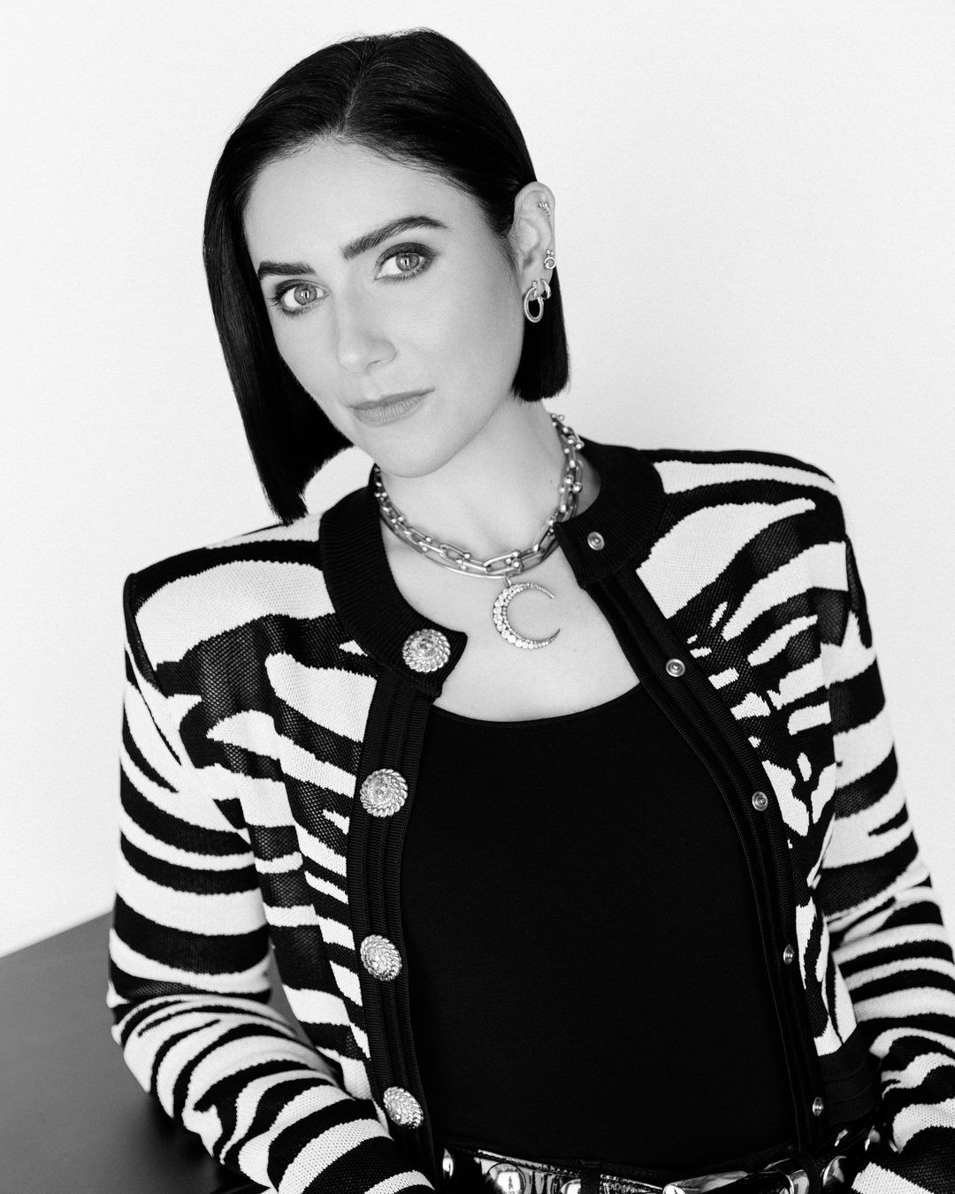 Black and white portrait of Lindy Firstenberg in a black and white patterned jacket.