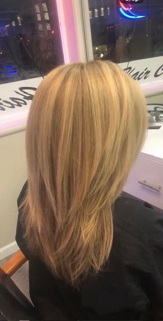 Blonde layered haircut viewed from the back in a salon chair