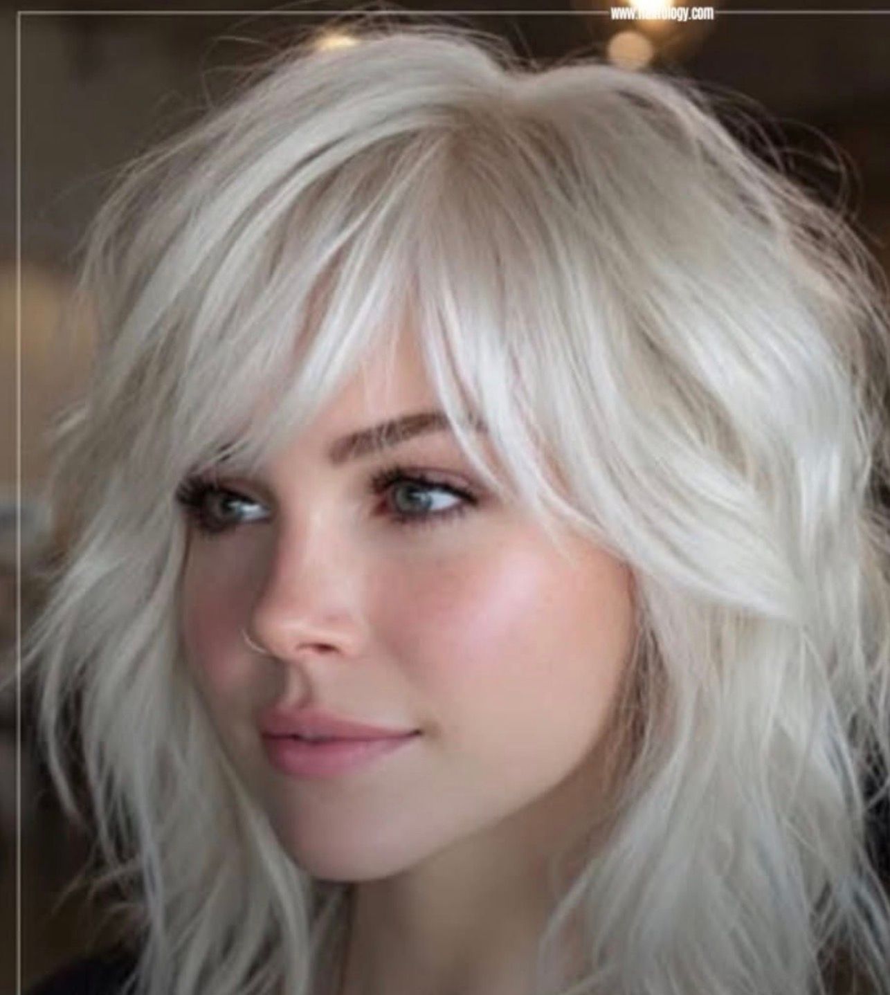 Portrait of a person with platinum blonde hair, looking left with a soft expression.
