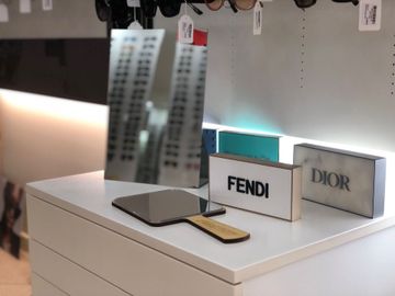 un tavolo con uno specchio e un cartello con scritto fendi
