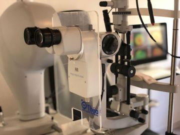 un microscopio è seduto davanti al monitor di un computer.