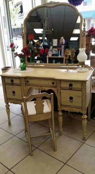Vintage cream vanity with oval mirror and chair in a tiled room