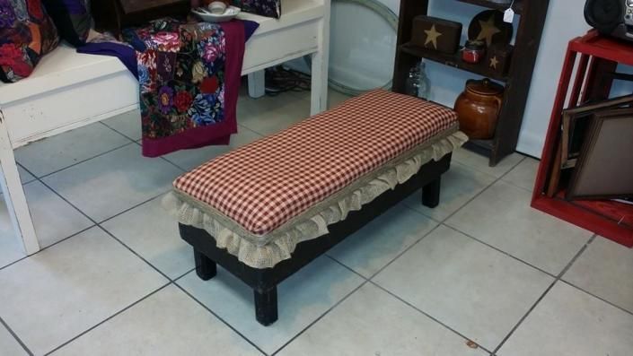 Small bench with a red checkered cushion on a tiled floor in a living room