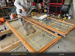 Man repairing wooden framed windows, indoors.
