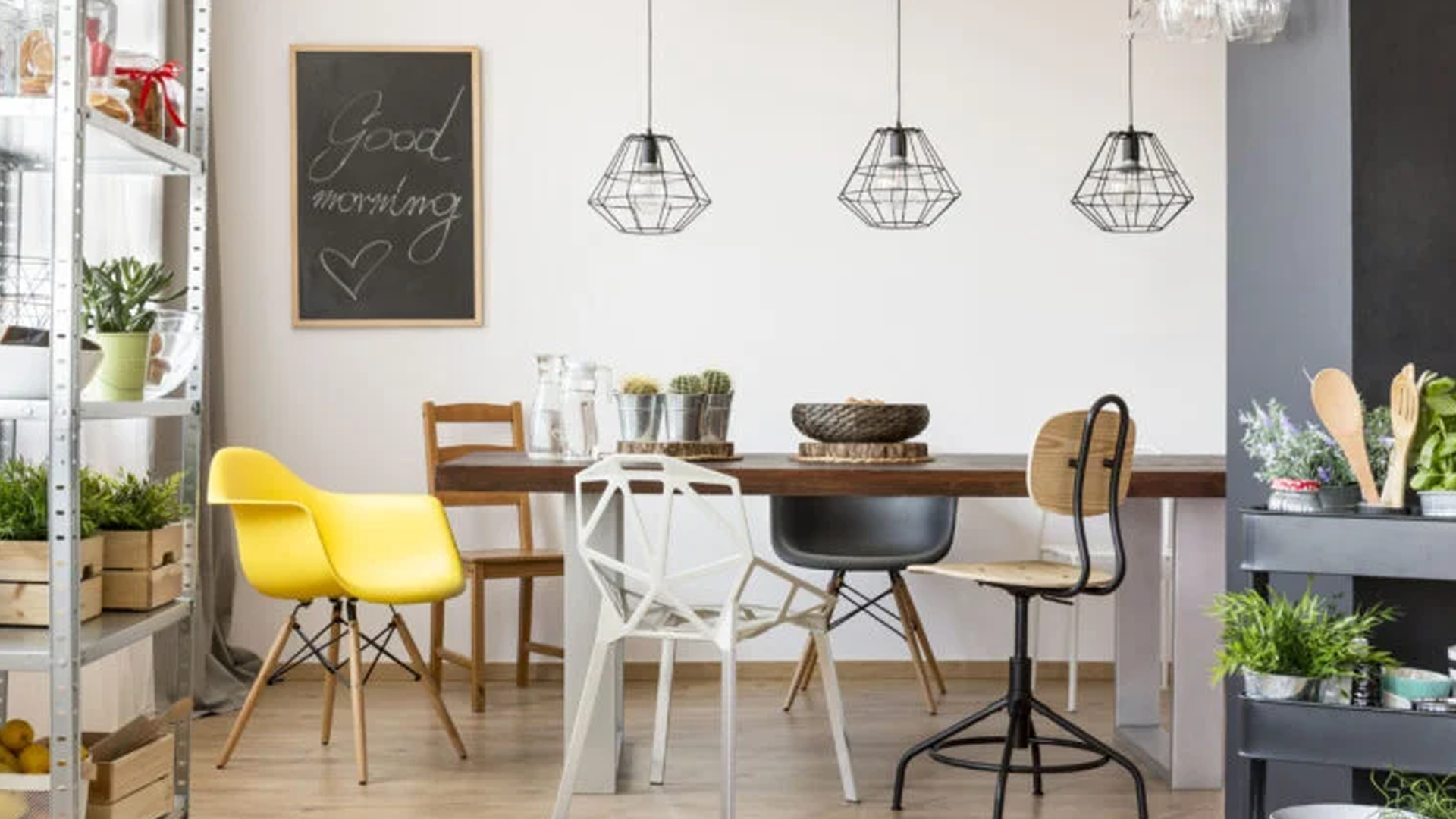 Uma sala de jantar com mesa e cadeiras e um quadro negro na parede.