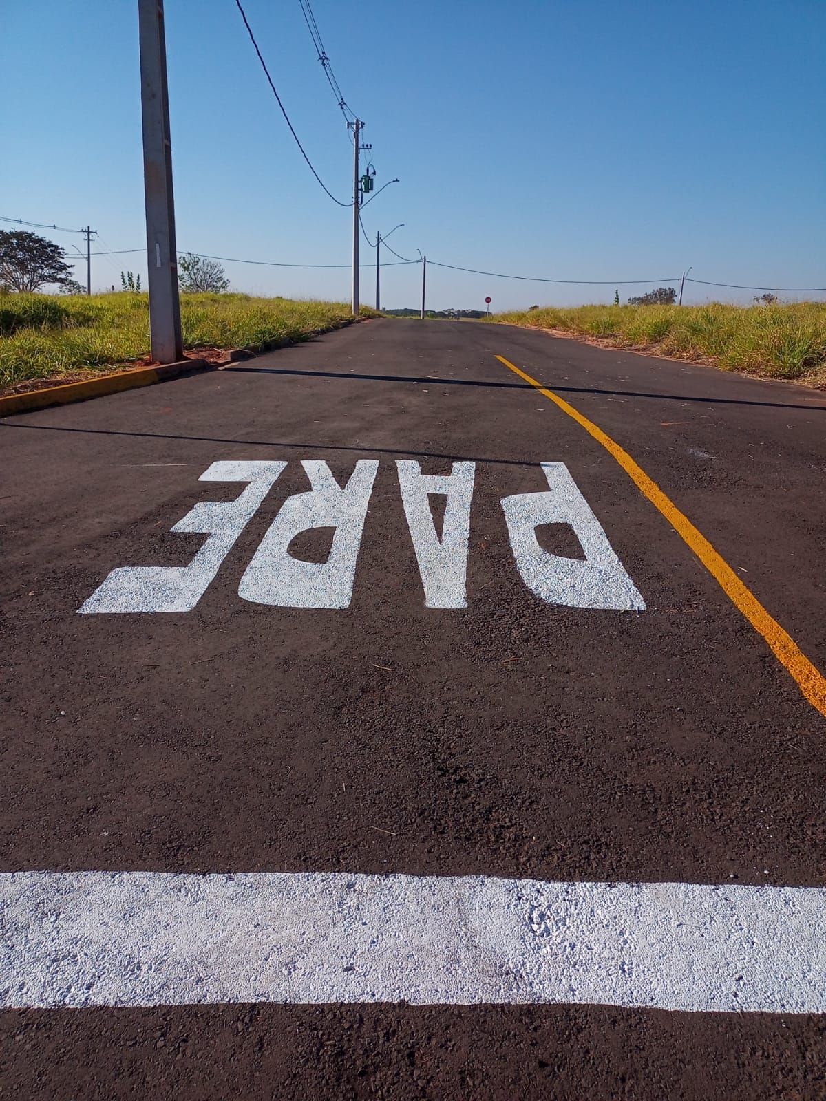A palavra pare está pintada na beira da estrada