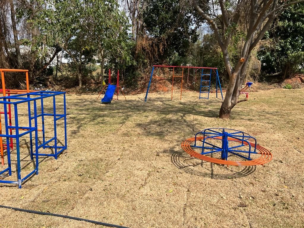Playground com balanços, carrossel e trepa-trepa.