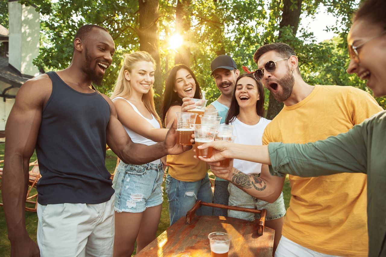 amigos-comemorando-em-condominio-fechado Um grupo de pessoas brinda com cerveja em um parque.
