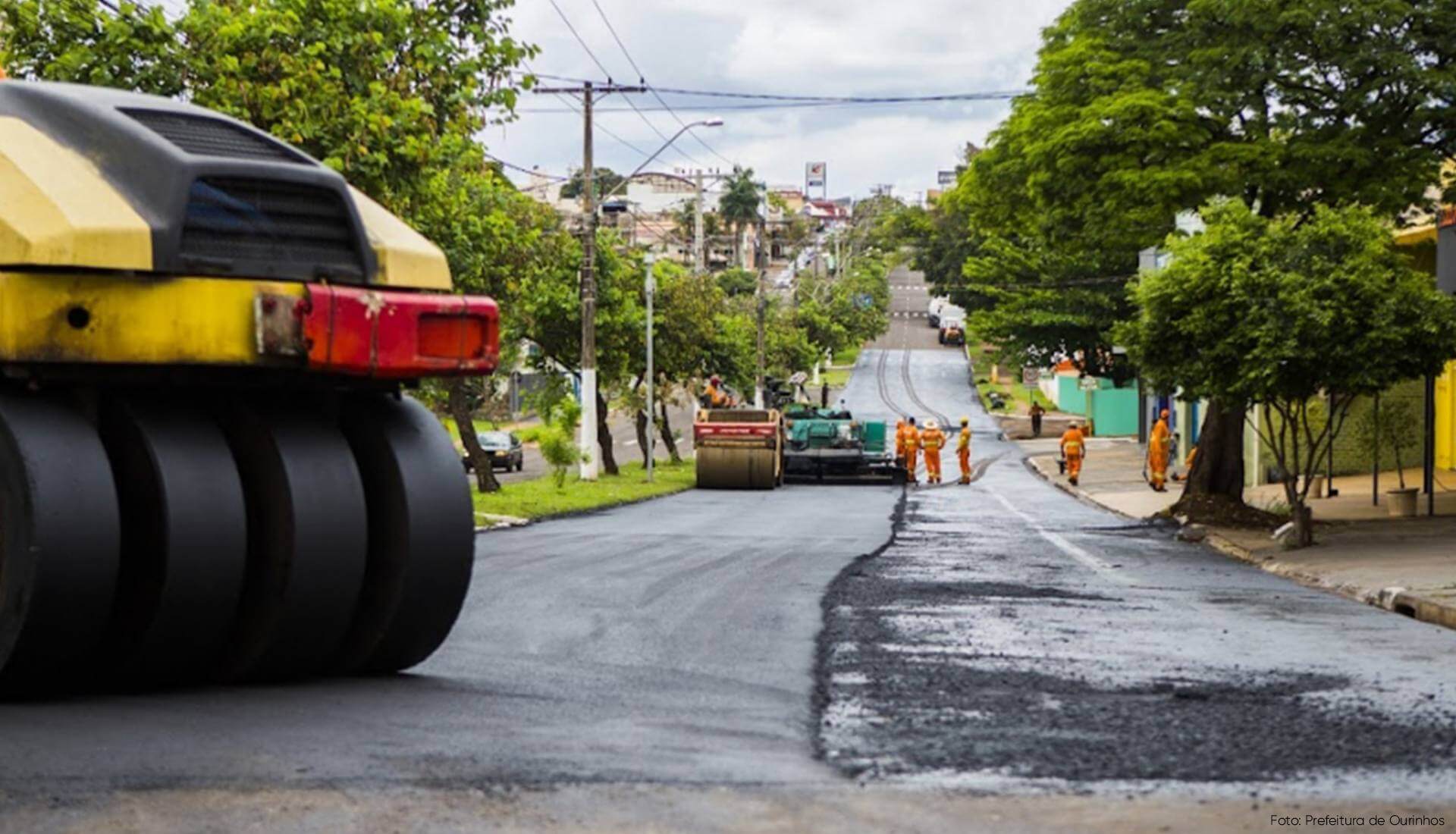asfaltando Um rolo compactador amarelo e preto está dirigindo por uma rua.