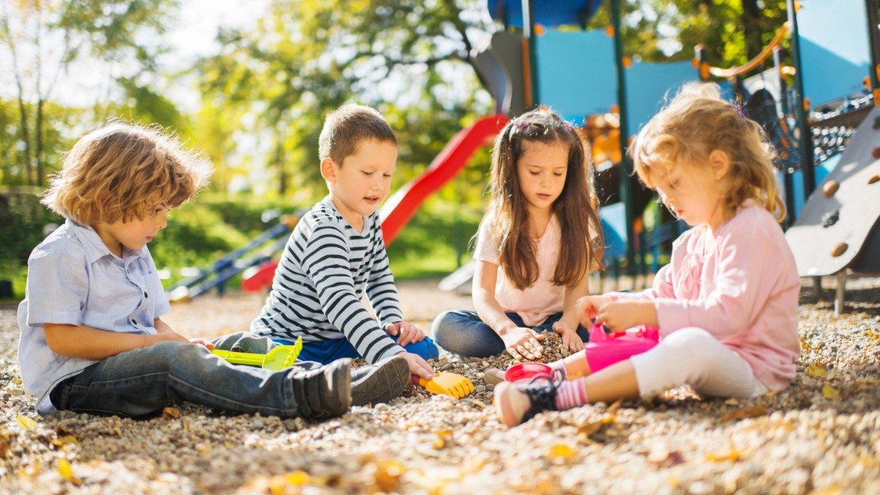 criancas-no-parque Um grupo de crianças brinca na areia de um playground.