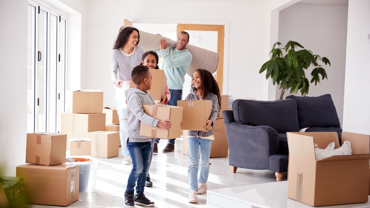 familia Uma família está carregando caixas para uma nova casa.