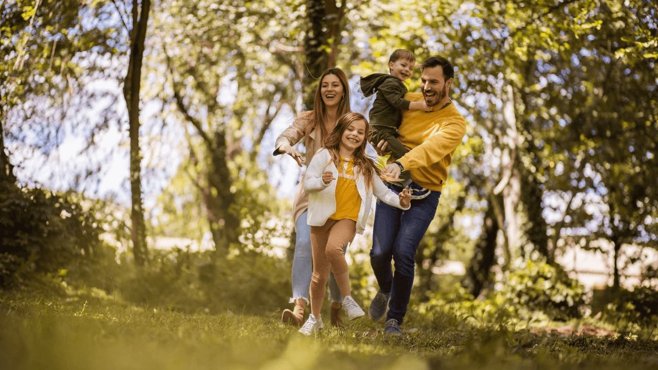 familia-no-parque Uma família está caminhando junta pela floresta.