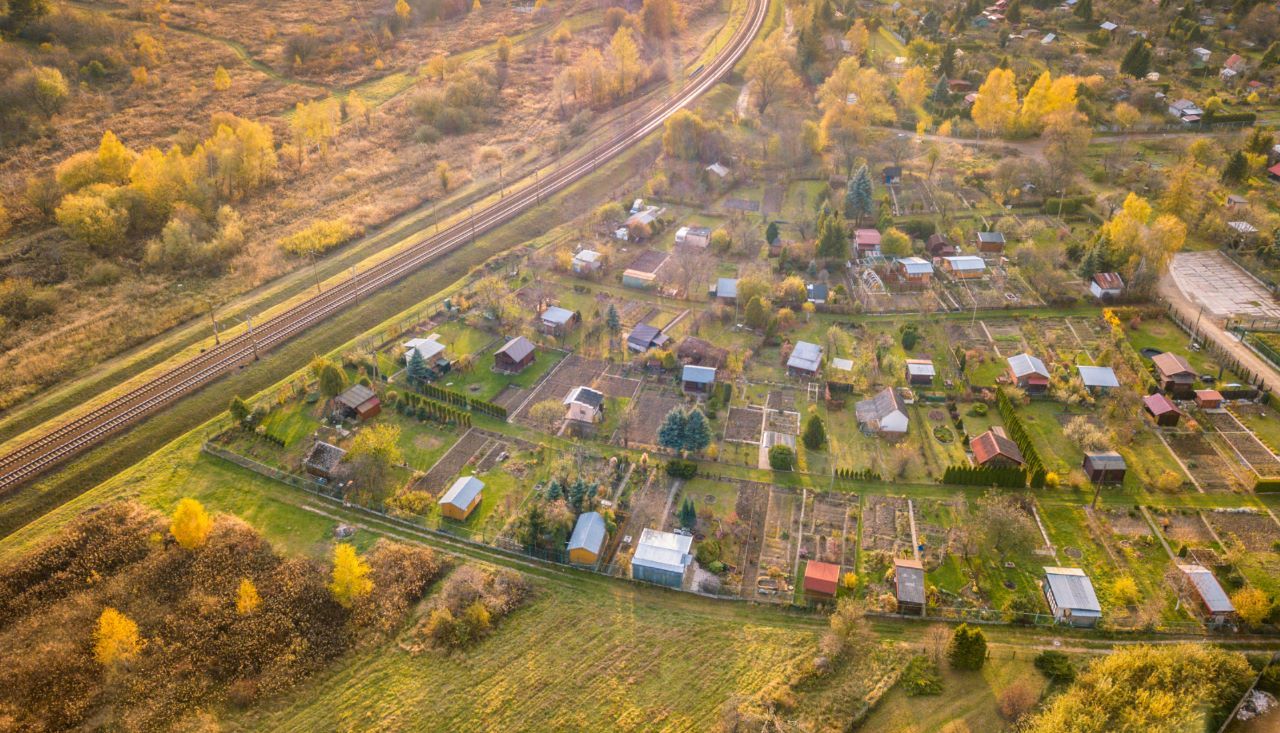 magem-aerea Uma vista aérea de uma área residencial com uma linha de trem ao fundo.