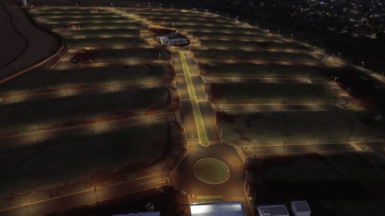 loteamentos Uma vista aérea de uma rua à noite com carros passando por ela.