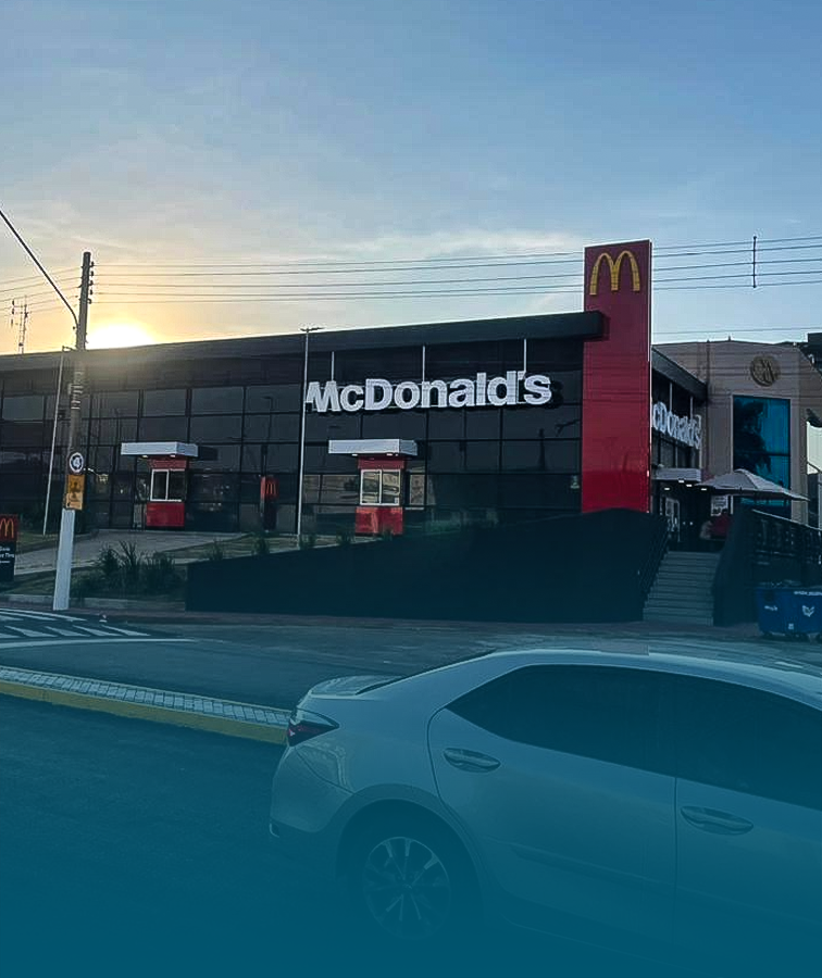Um restaurante McDonald's com um carro estacionado em frente