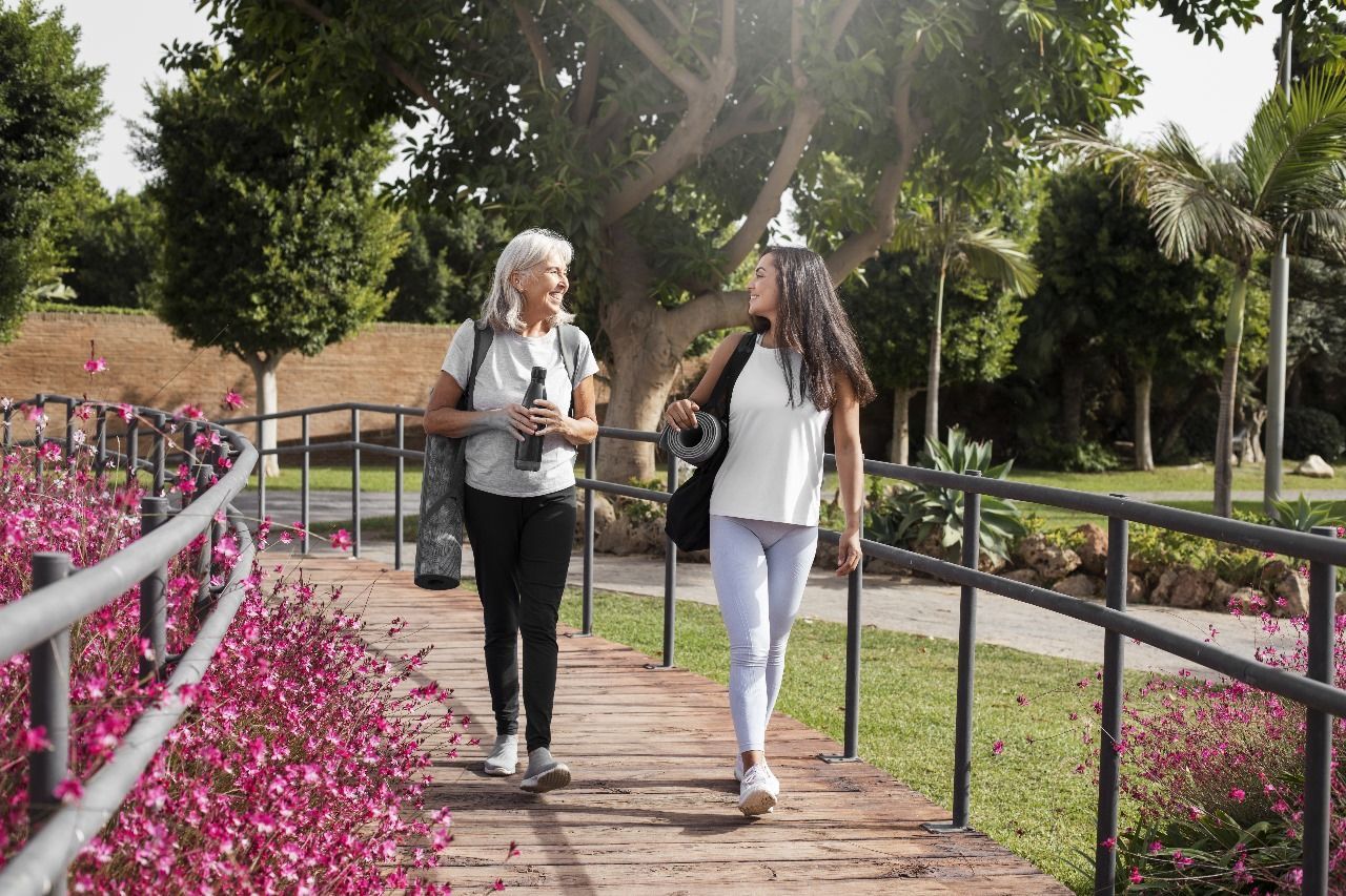 essoas-em-area-do-condominio Duas mulheres estão atravessando uma ponte em um parque.