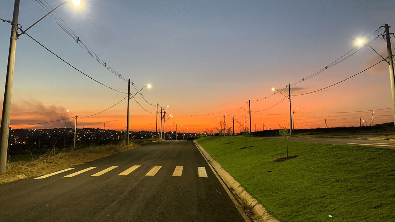 rua-lotes Uma estrada com faixa de pedestres e pôr do sol ao fundo