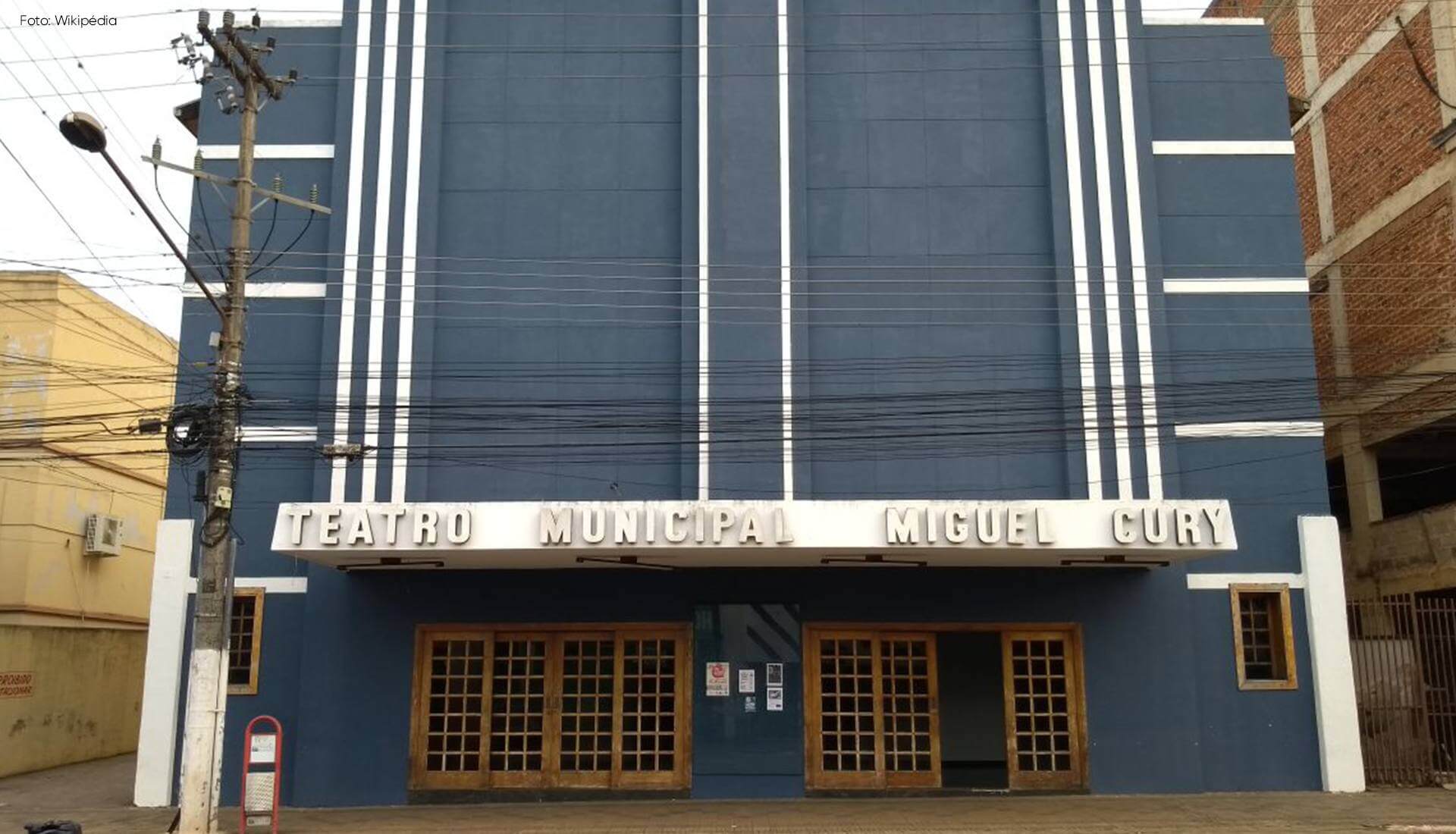 teatro-municipal Um prédio azul com uma placa que diz teatro municipal miguel curl