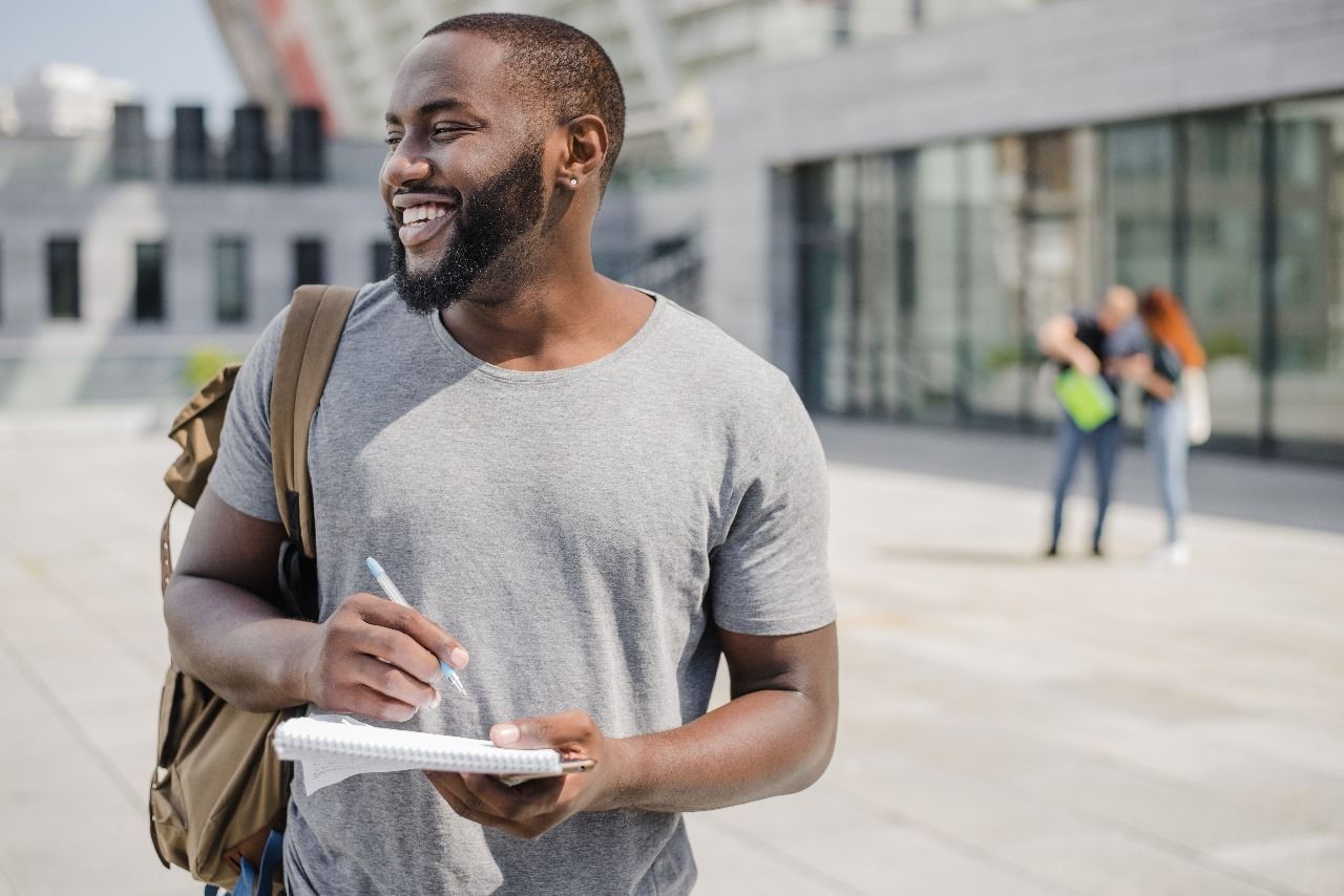 vantagens-de-viver-em-ourinhos Um homem com uma mochila está escrevendo em um pedaço de papel.