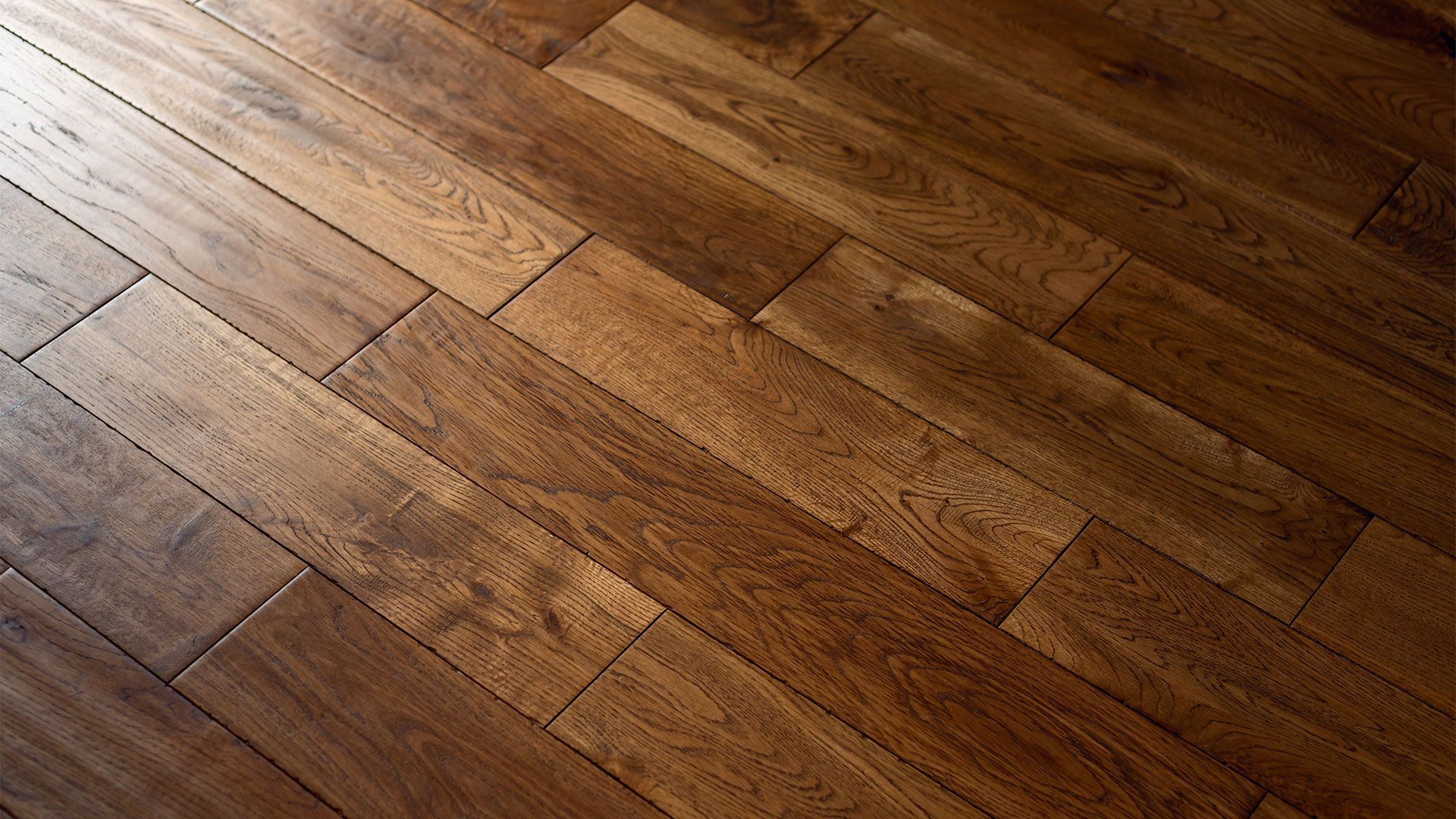 Diagonal view of warm brown hardwood floor planks with visible wood grain and seams
