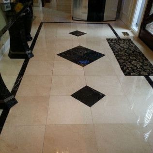 Glossy lobby floor with beige tiles and black diamond inlays, seen from a doorway