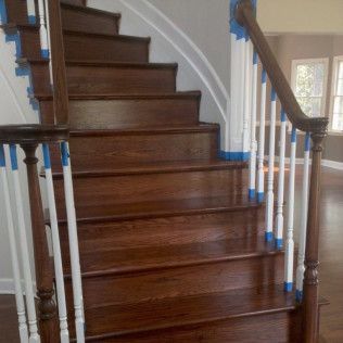 Curved wooden staircase with white banisters in a bright home interior