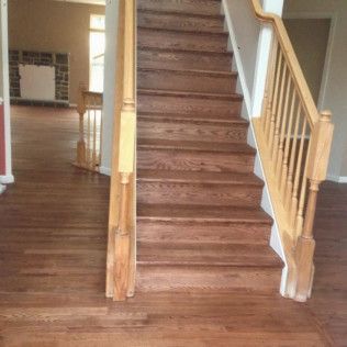 Staircase with brown carpeted steps and wooden railing in a home interior