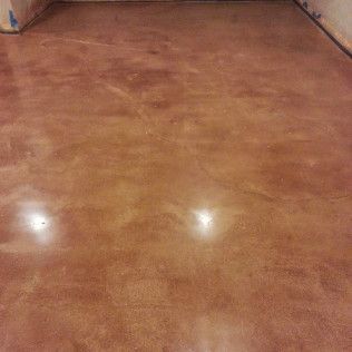 Glossy brown floor in a mostly empty room with light reflections