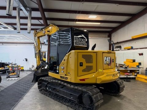 Yellow CAT mini excavator in a workshop.
