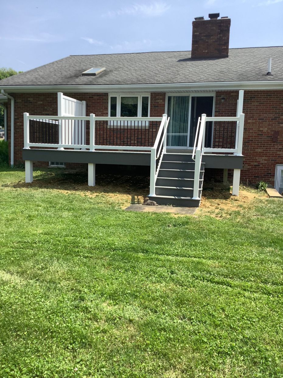 There is a large deck with a table and chairs on it.