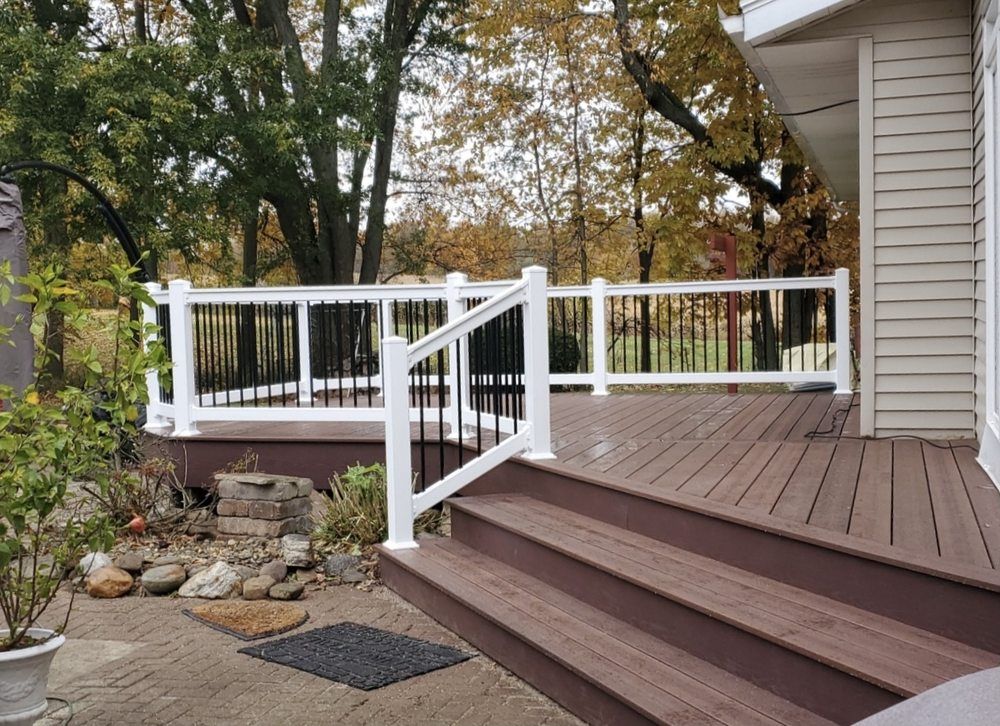 A wooden deck with stairs and a white railing