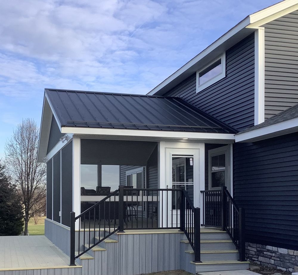 A blue house with a screened in porch and stairs