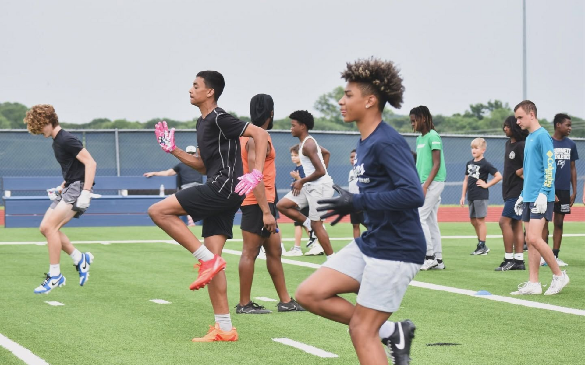Athletes practicing running drills outdoors