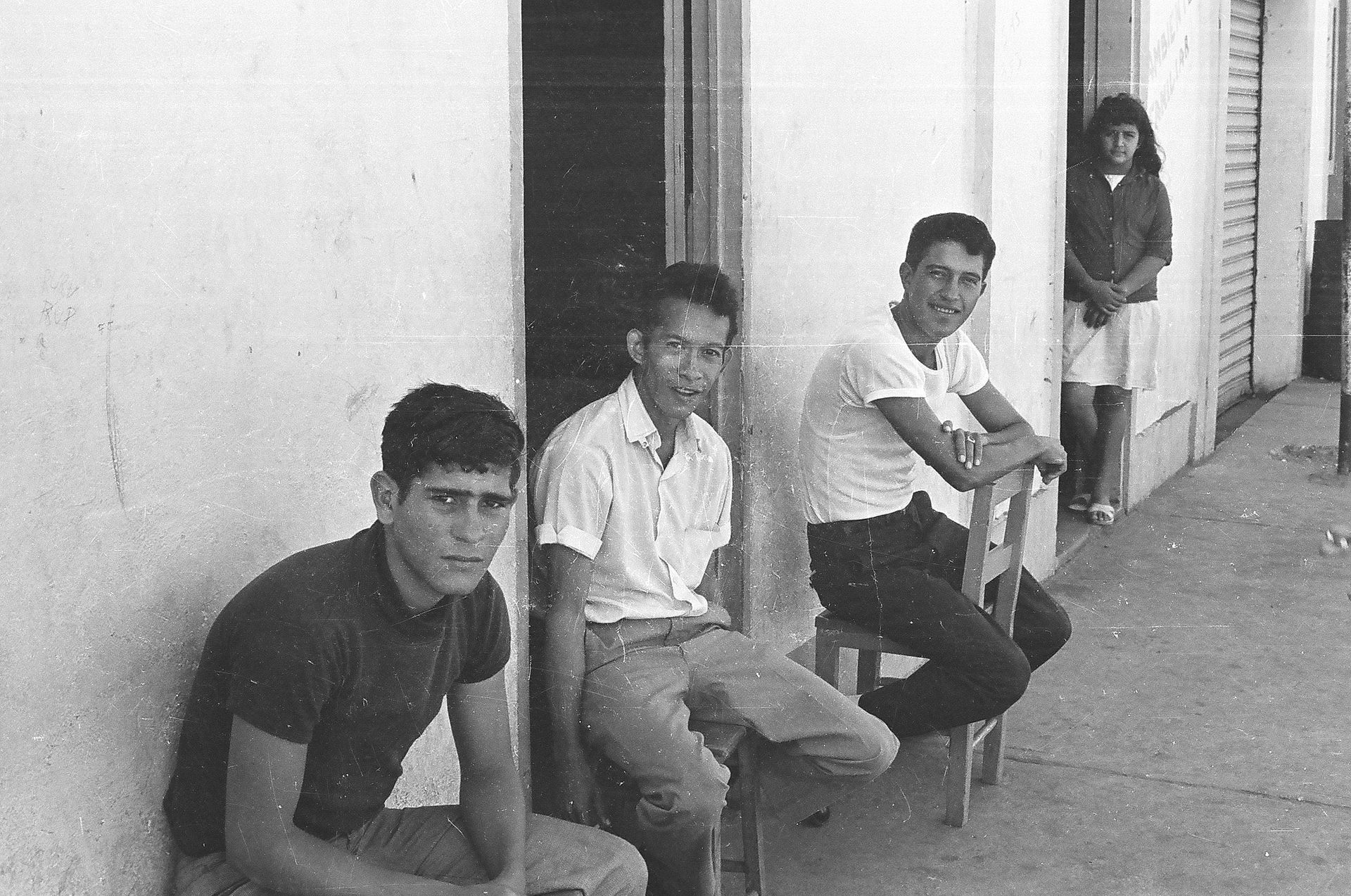 A group of young men are sitting in front of a building
