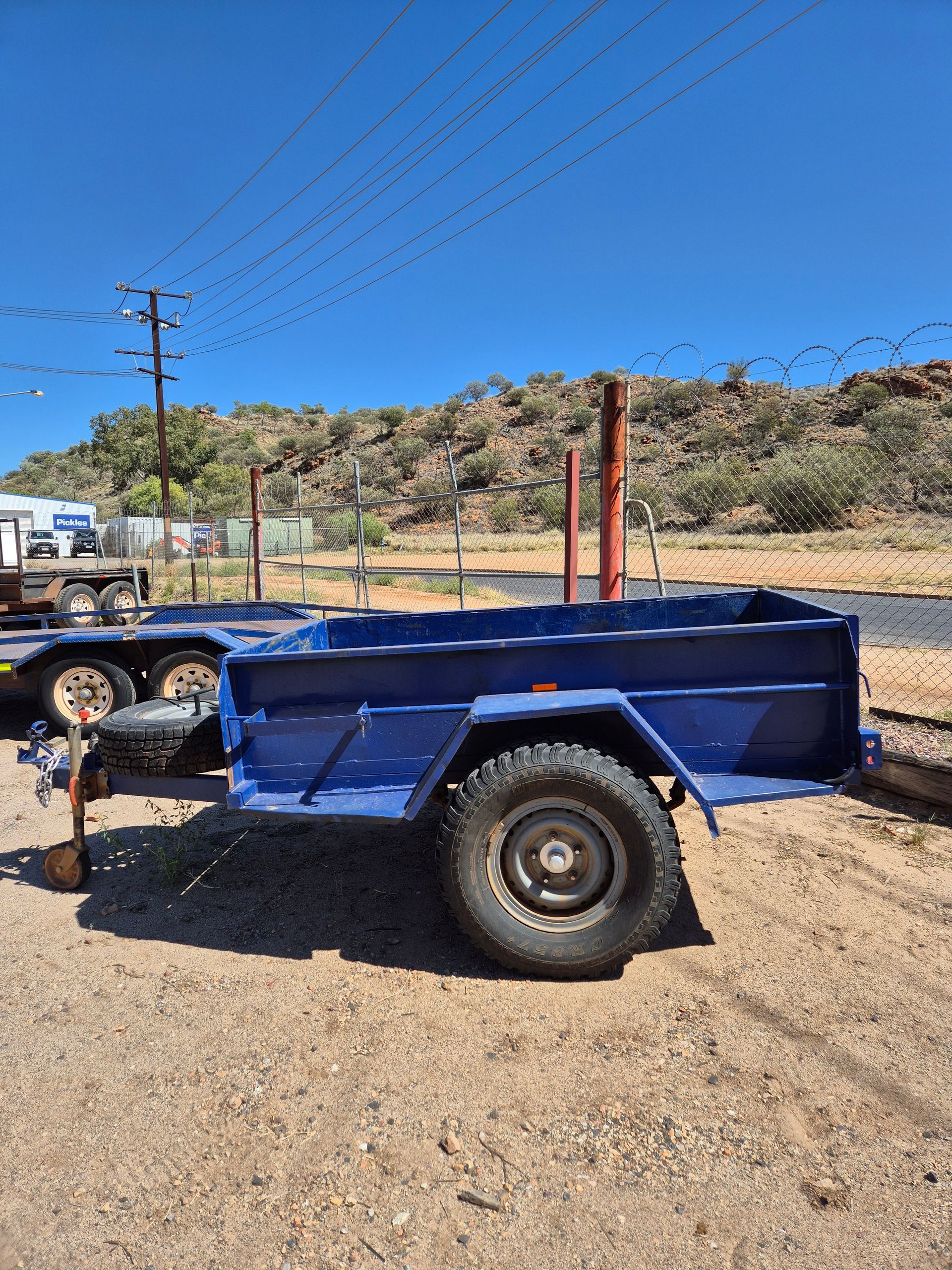 Blue Utility Trailer Parked on Gravel in Front of A Hill and Power Lines — Centre Trailer Sales In Alice Springs, NT