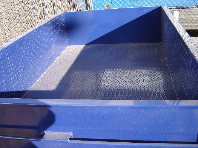 A Blue Container With Holes In It Is Sitting In Front Of A Fence — Centre Trailer Sales In Alice Springs, NT