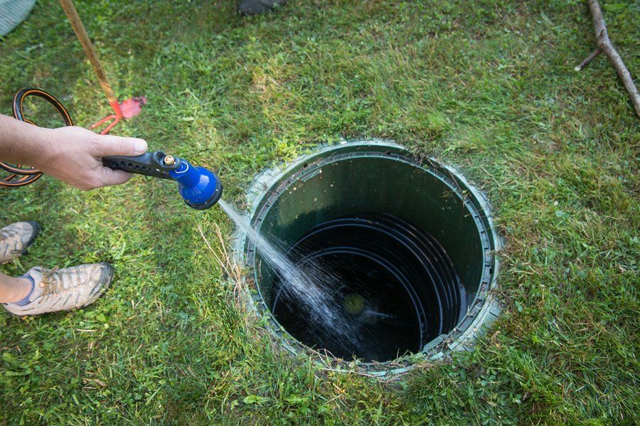 man spraying water in the septic tank
