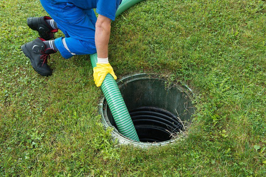 man putting hose in the septic tank