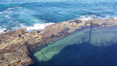 A Pool of Water Surrounded by Rocks Next to the Ocean — Coastal Kerb and Concrete In Morisset, NSW