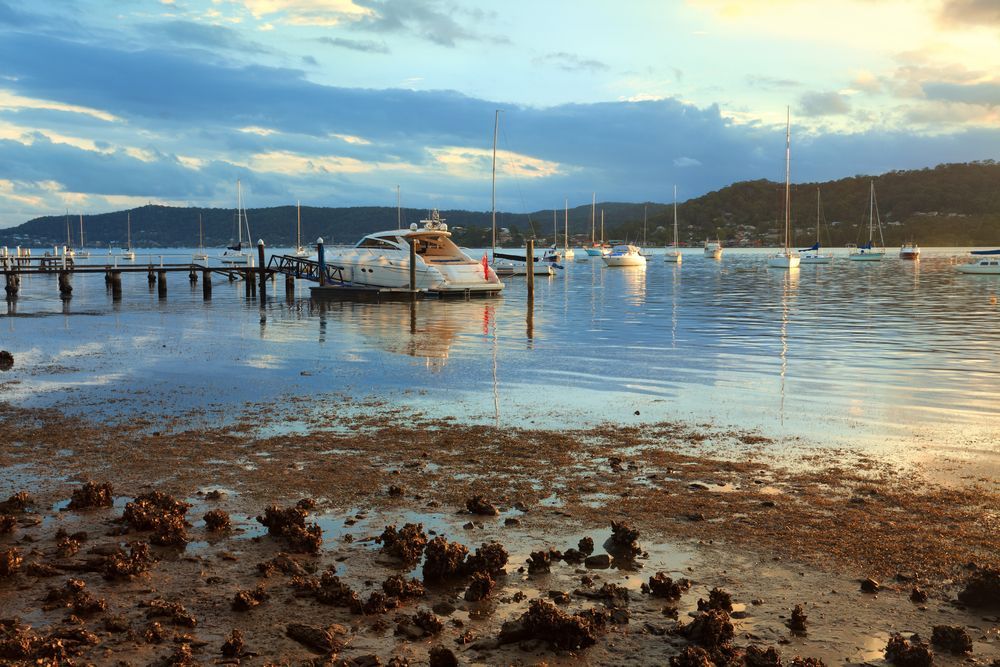 A Boat is Docked in the Water Near a Dock — Coastal Kerb and Concrete In Gosford, NSW