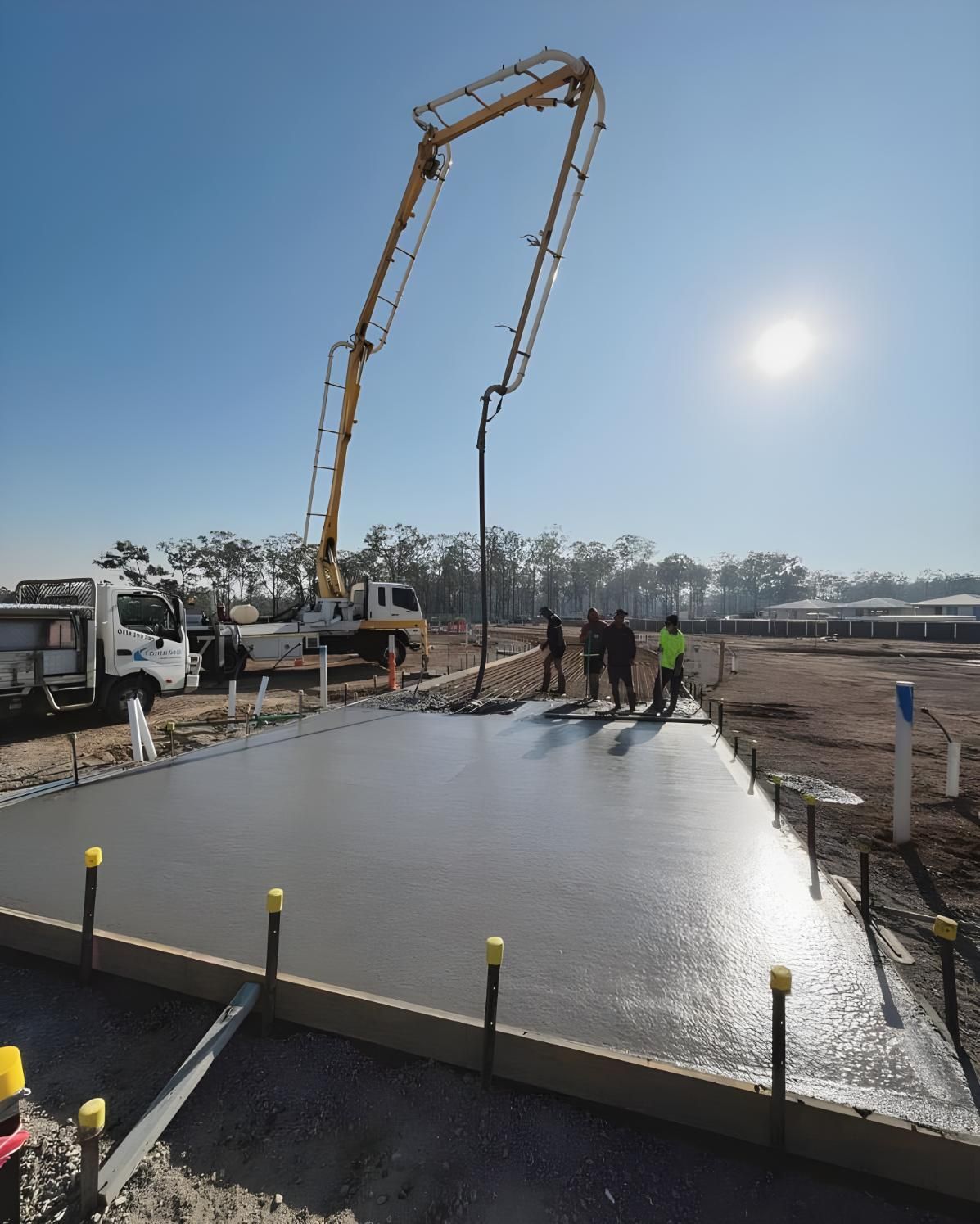 A Concrete Pump is Being Used to Pour Concrete on a Construction Site — Coastal Kerb and Concrete In Woongarrah, NSW