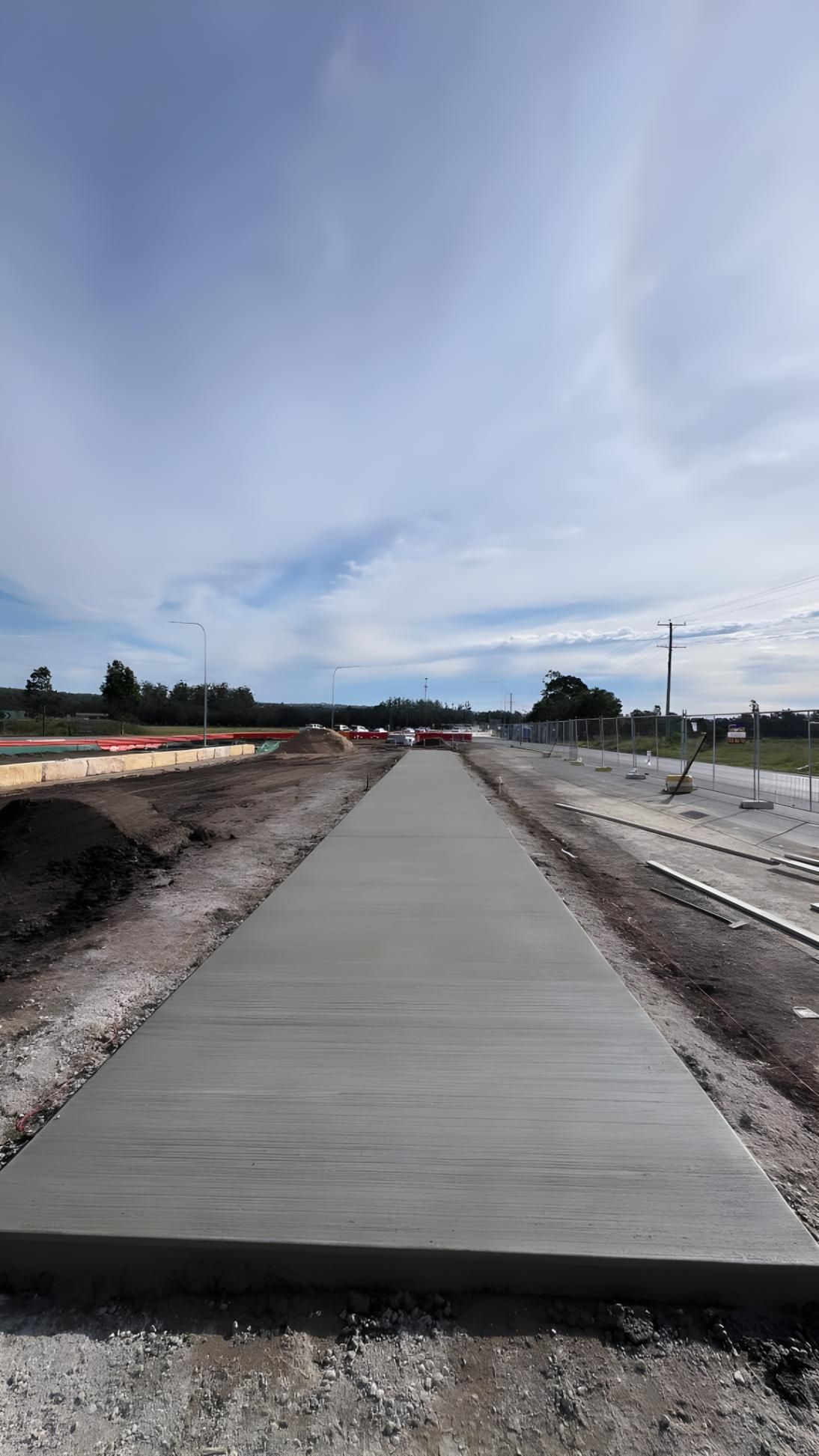 A Concrete Walkway is Being Built on the Side of a Road — Coastal Kerb and Concrete In Lake Macquarie, NSW