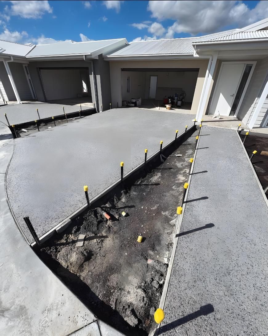 A Concrete Driveway is Being Built in Front of a House — Coastal Kerb and Concrete In Newcastle, NSW