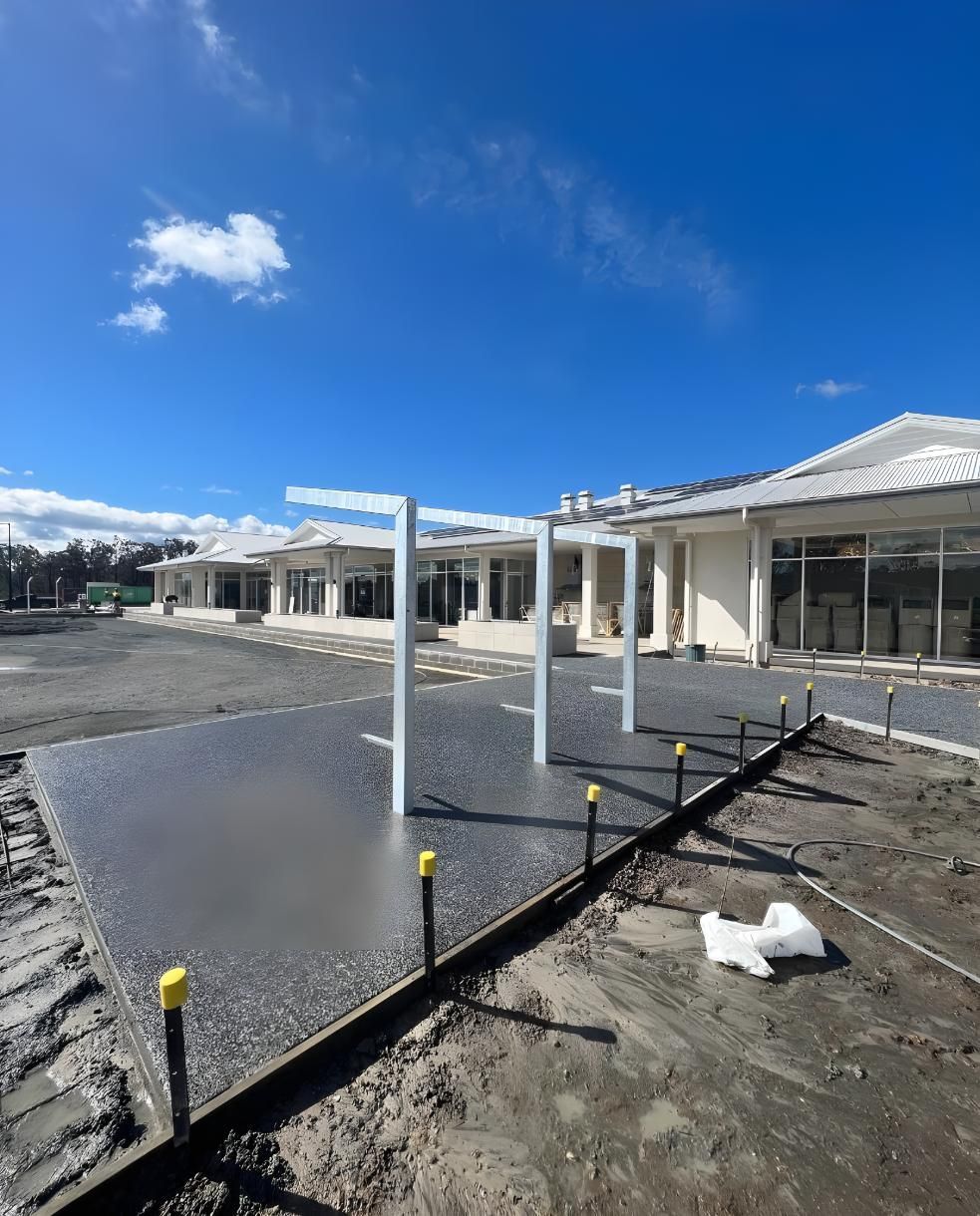 A Large Building With a Lot of Windows is Being Built — Coastal Kerb and Concrete In Lake Macquarie, NSW