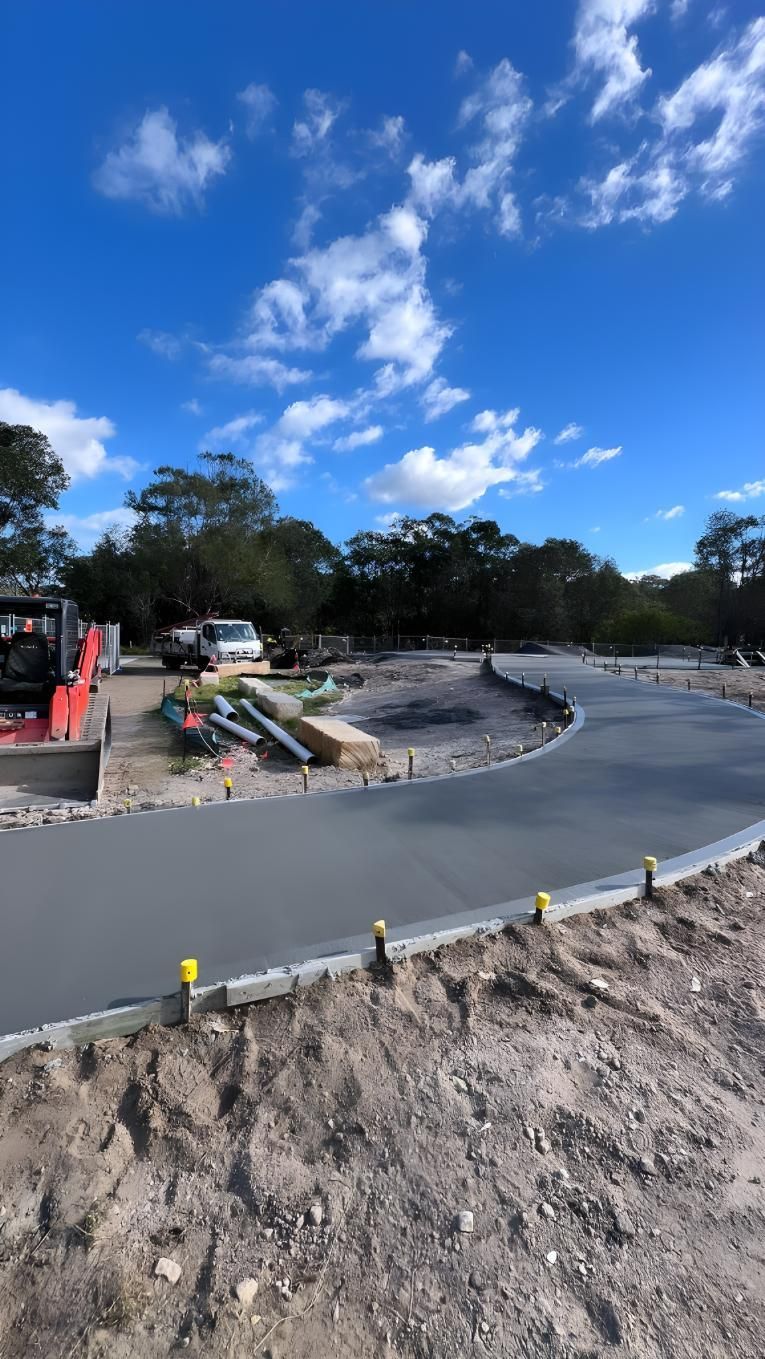 A Concrete Road is Being Built in the Middle of a Dirt Field — Coastal Kerb and Concrete In Wyee, NSW