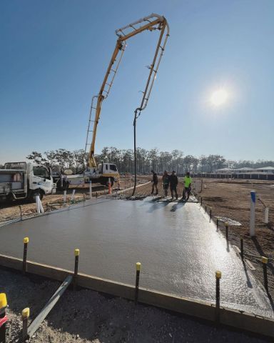 A Concrete Pump is Being Used to Pour Concrete on a Construction Site — Coastal Kerb and Concrete In Buff Point, NSW