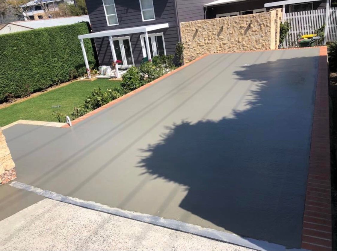 A Concrete Driveway is Being Built in Front of a House — Coastal Kerb and Concrete In Buff Point, NSW